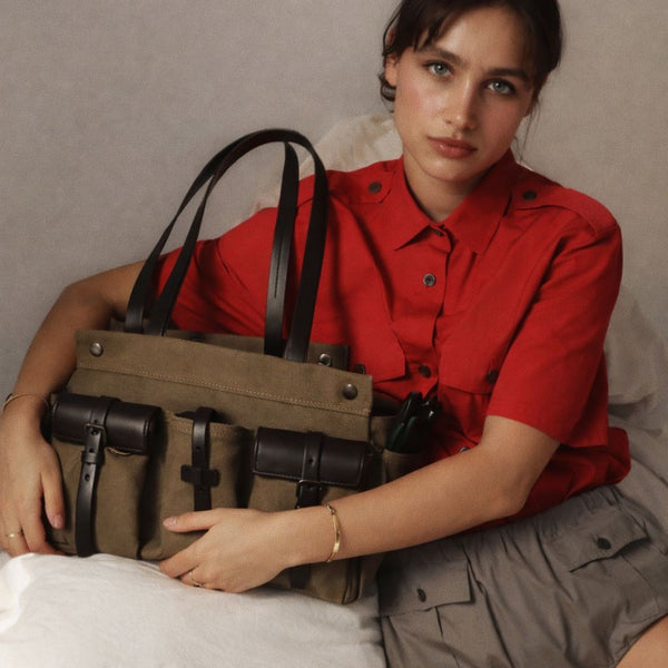 Large olive canvas shoulder tote bag with multiple front buckle-strap pockets and dark brown leather-look trim, detail view 3