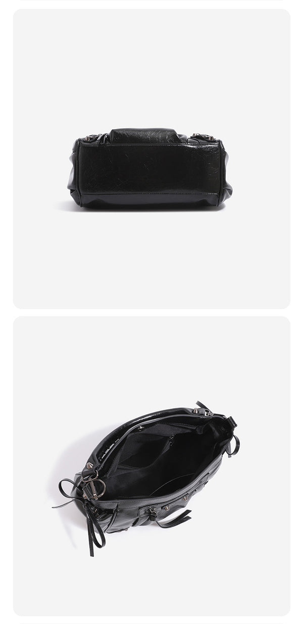 Glossy crinkled slouchy shoulder bag with silver-tone studs, fringe tassel pulls, front zip pocket, and arched top handle