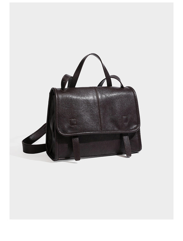 Strukturierte Satchel-Tasche mit Überschlag aus dunkelbrauner, glänzender Lederoptik, kurzem Tragegriff und langem, verstellbarem Schulterriemen