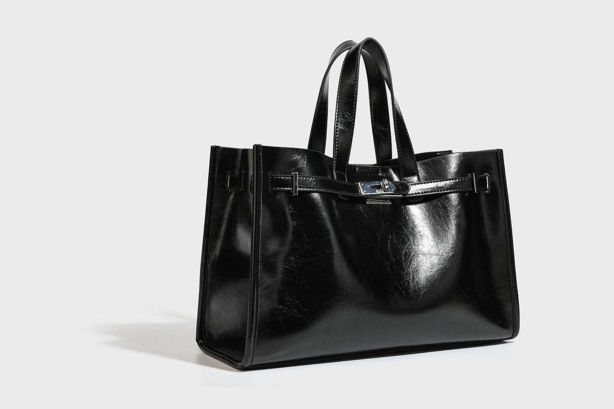 Strukturierte, glänzende Tote-Bag in Lederoptik mit silberfarbenem Drehverschluss, zwei Tragegriffen und abnehmbarem Schulterriemen, Detailansicht