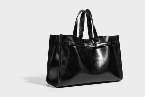 Strukturierte, glänzende Tote-Bag in Lederoptik mit silberfarbenem Drehverschluss, zwei Tragegriffen und abnehmbarem Schulterriemen, Detailansicht