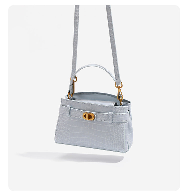 Small structured crocodile-embossed top-handle bag with gold-tone turn-lock closure and detachable shoulder strap, detail
