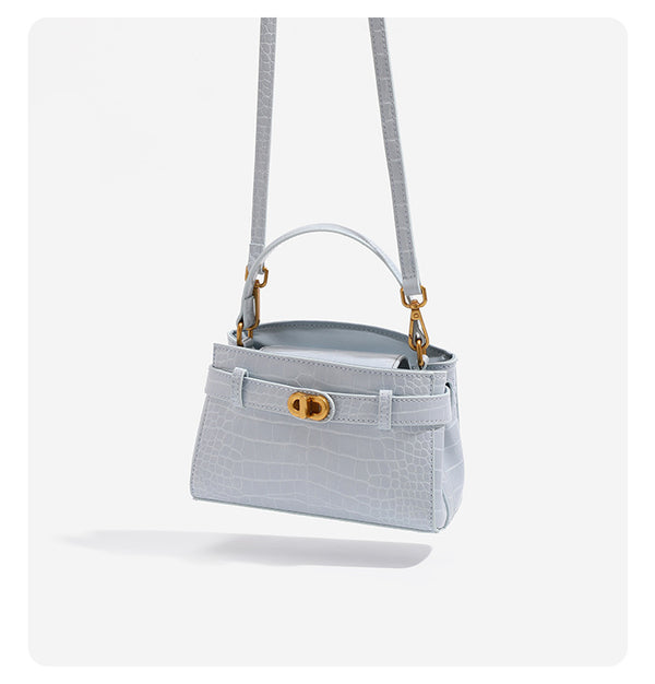 Small structured crocodile-embossed top-handle bag with gold-tone turn-lock closure and detachable shoulder strap, detail