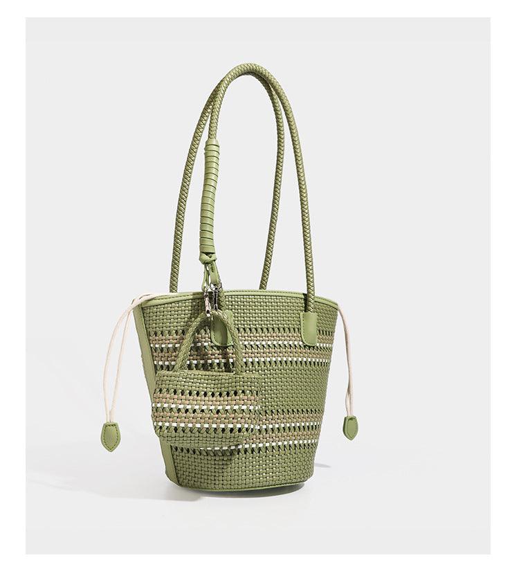 Light blue open-weave woven bucket tote bag with long braided shoulder straps, drawstring side ties, and attached mini pouch