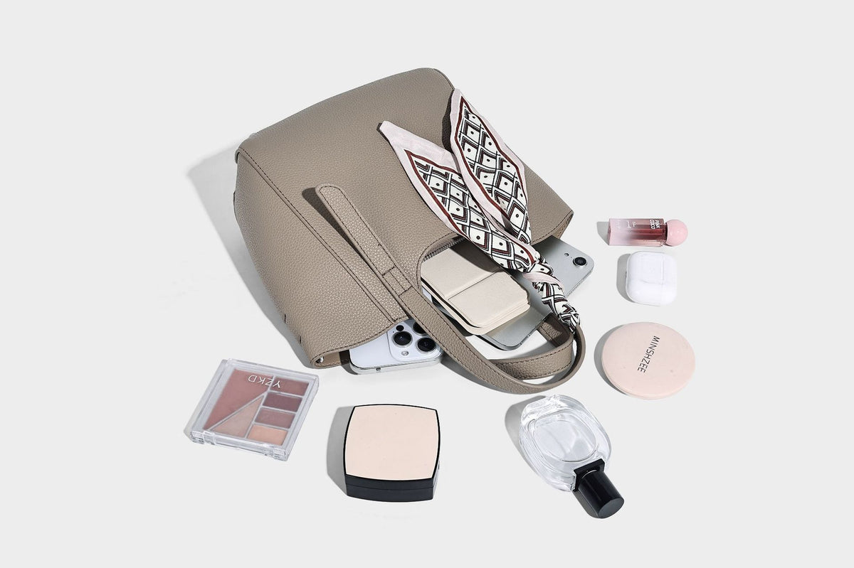 Structured pebbled leather-look tote bag with detachable scarf tie, dual top handles, and adjustable crossbody strap, detail