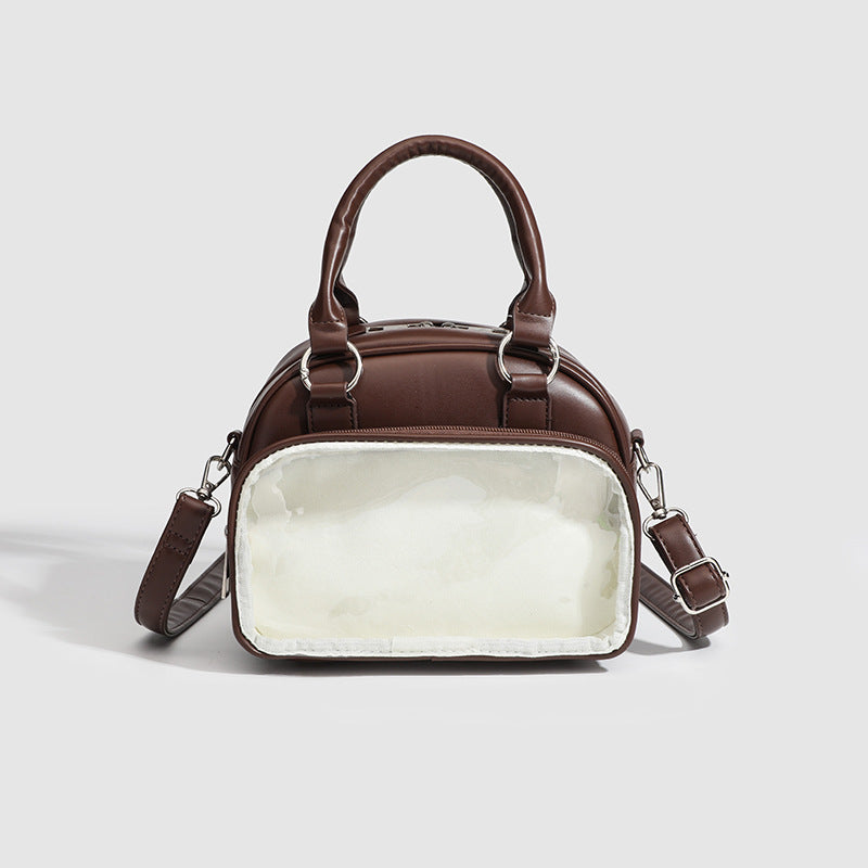 Structured mini bowling barrel bag with clear front pocket, dual top handles, and detachable crossbody strap in glossy