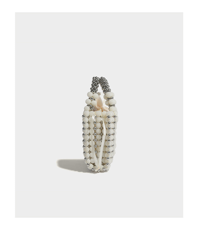 Small boxy pearl-bead mini top-handle bag with silver metallic bead accents, satin floral detail, and long beaded shoulder