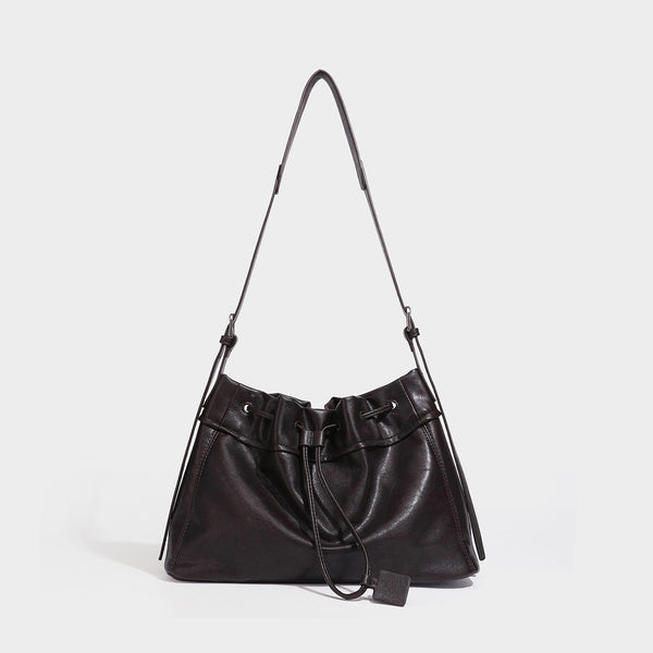 Slouchy drawstring bucket bag in dark brown leather-look finish with long adjustable shoulder strap and gathered tie closure