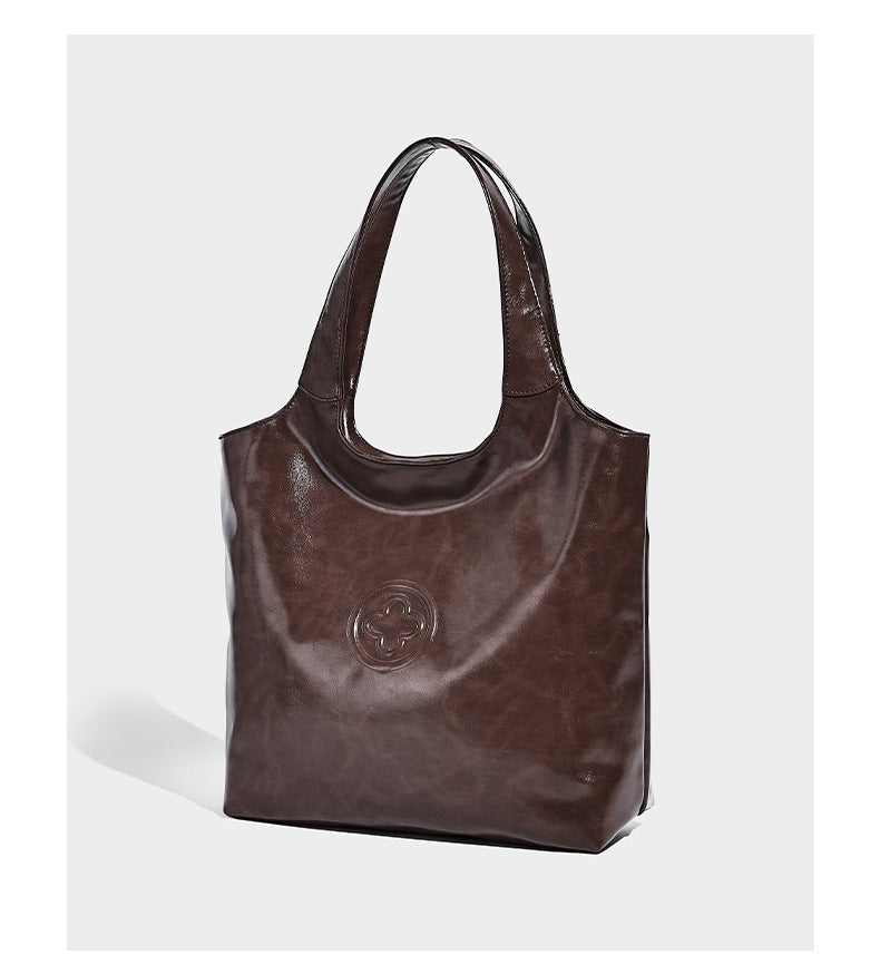 Glossy oil-wax leather-look open-top tote shoulder bag with embossed circular logo and long double straps, detail view 9