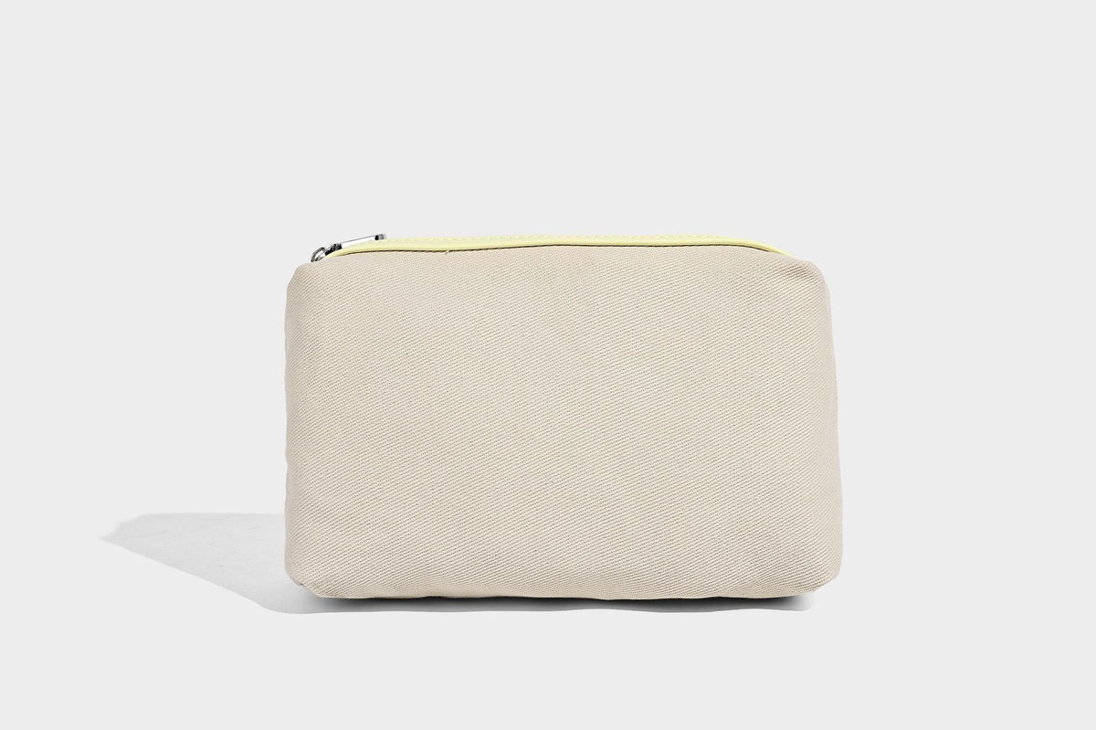 Structured trapezoid tote bag in pebbled leather-look finish with double top handles, silver-tone bar hardware, and, detail