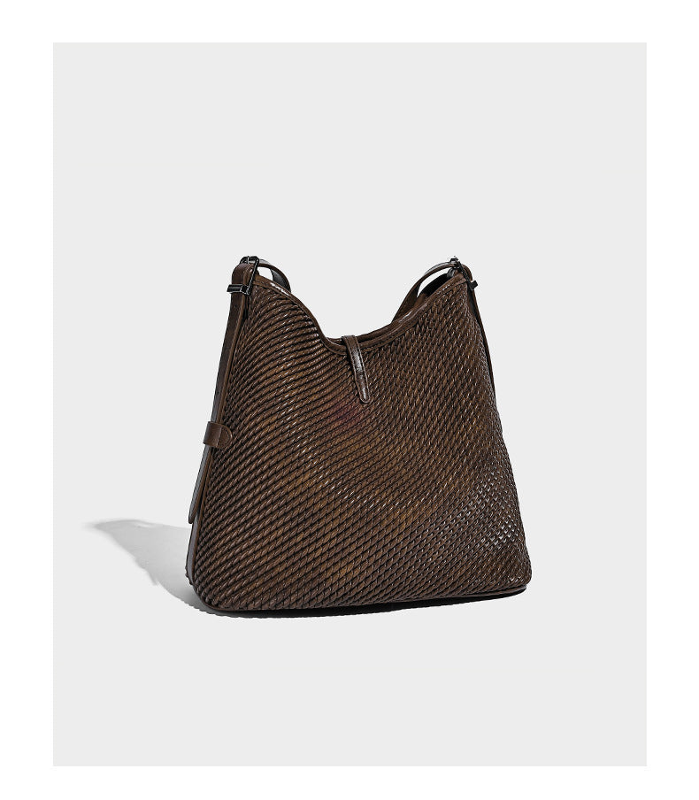 Große Schultertasche im Beuteltaschenstil mit Flechtstruktur, glatten Besätzen in Lederoptik, verstellbarem Riemen und Anhänger-Detail, Detailansicht