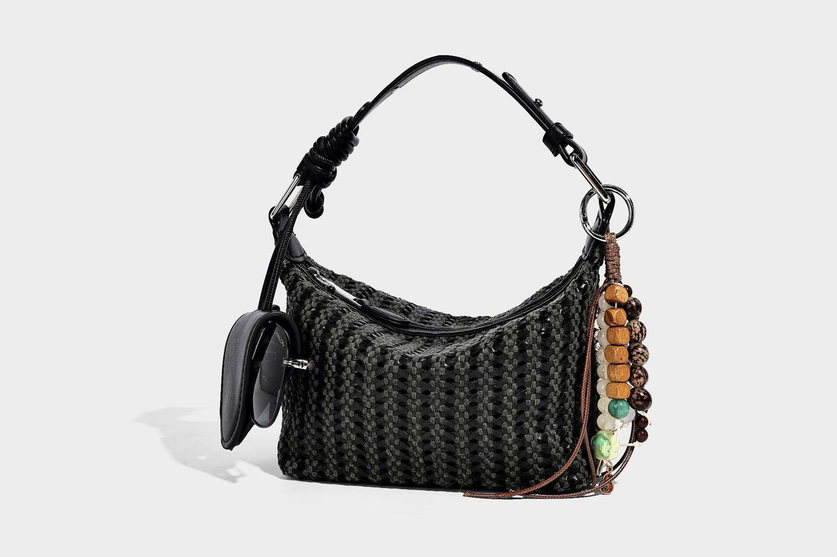 Woven crescent shoulder bag with leather-look knotted handle, zip top, attached mini pouch, and silver-tone hardware, detail