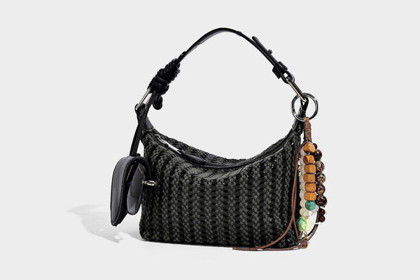 Woven crescent shoulder bag with leather-look knotted handle, zip top, attached mini pouch, and silver-tone hardware, detail