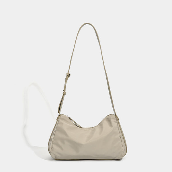 Soft crescent shoulder bag in smooth sheen nylon with contrast leather-look trim, slim adjustable strap, and top zip closure