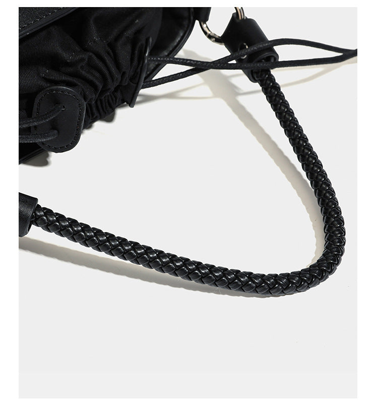 Small structured woven checker bucket bag with braided top handle, drawstring closure, and silver-tone hardware in black