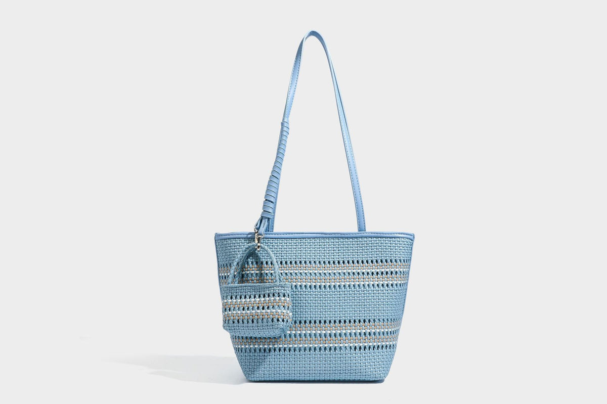 Large structured woven tote bag with striped basket-weave finish, long shoulder straps, and detachable mini pouch charm