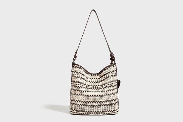 Woven stripe bucket shoulder bag in cream and dark brown with leather-look trim, knotted adjustable strap, and small shield