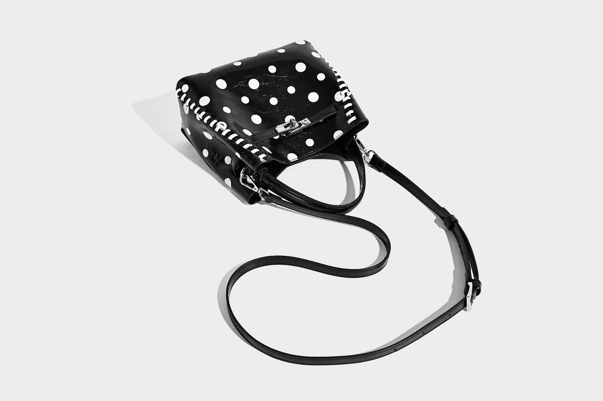 Glänzende, geknautschte Beuteltasche mit Polka-Dots, silberfarbenen Schnallenbeschlägen, kontrastierendem seitlichem Schnürbesatz, Tragegriff und abnehmbarem