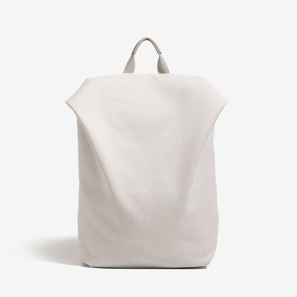 Minimalistische matte Rucksacktasche in geflochtener Optik mit kurzem Tragegriff und verstellbaren Schulterriemen, Vorderansicht