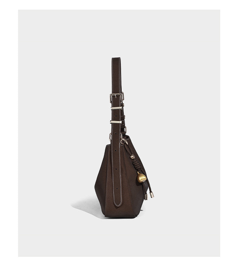Crescent hobo shoulder bag in pebbled leather-look finish with top zipper, adjustable strap, gold-tone ring hardware, and