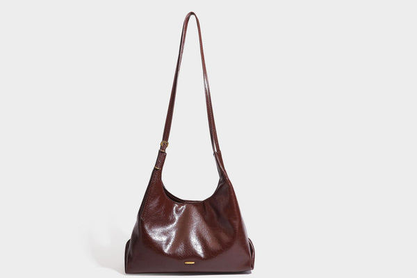 Locker fallende Hobo-Schultertasche mit offenem Oberteil aus glänzendem, geknautschtem Lederimitat in Dunkelbraun, mit schmalem verstellbarem Riemen und goldfarbenem