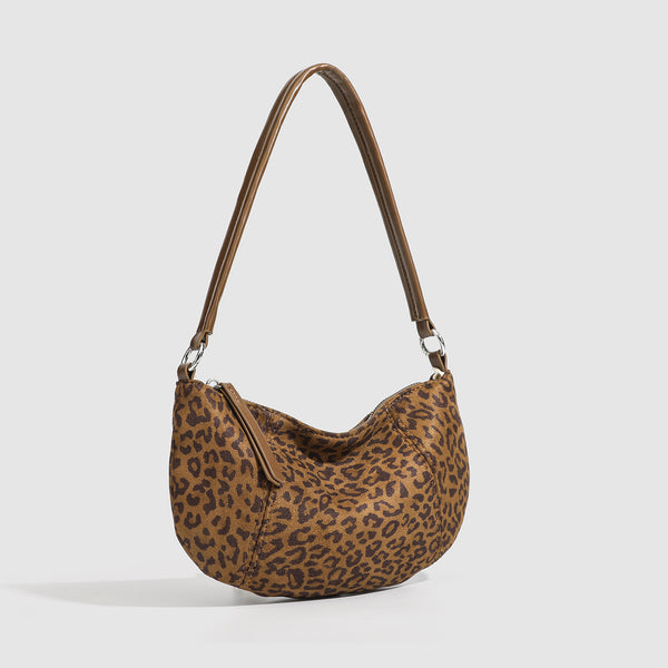 Brown and tan leopard print crescent hobo shoulder bag with zip top closure, front zip pocket, and adjustable silver-tone