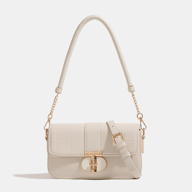Small structured crocodile-embossed flap shoulder bag with circular gold turn-lock closure and chain-accent strap, detail