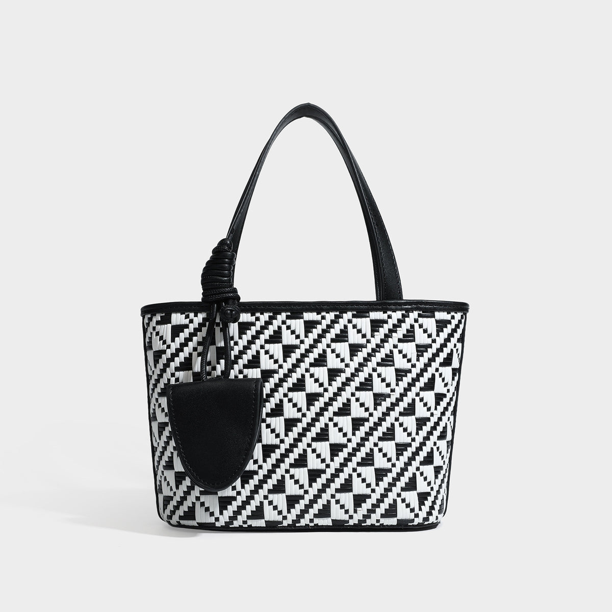 Kleiner, strukturierter Shopper mit gewebtem geometrischem Muster, glatten Besätzen in Lederoptik, geknoteten Henkeln, Reißverschluss und herabhängendem Frontdetail