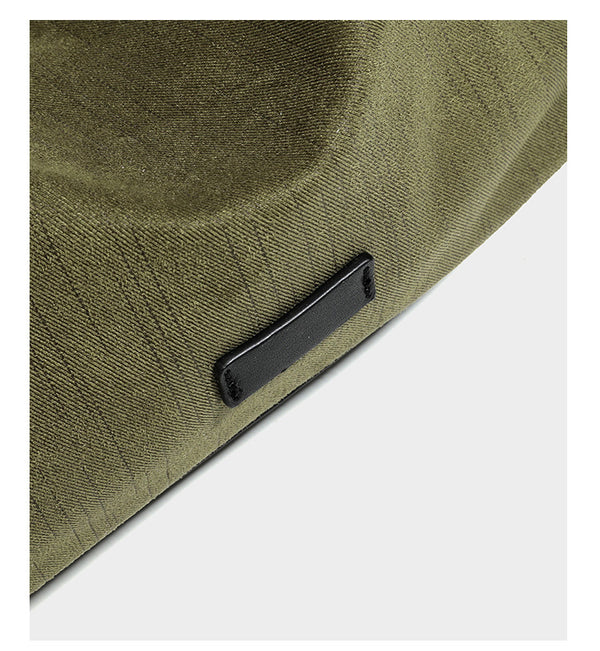 Slouchy olive green canvas hobo shoulder bag with black leather-look trim, zip-top closure, and adjustable strap, detail view