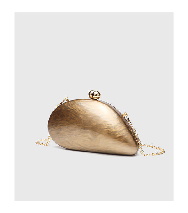Ovale Hartschalen-Clutch in marmorierter Perlmuttoptik mit Verschluss aus zwei goldfarbenen Kugeln und goldfarbener Kettenriemen, Detailansicht