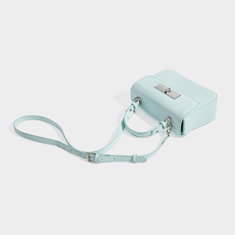 Small structured rectangular satchel with glossy crocodile-embossed finish, arched top handle, front flap, and silver-tone