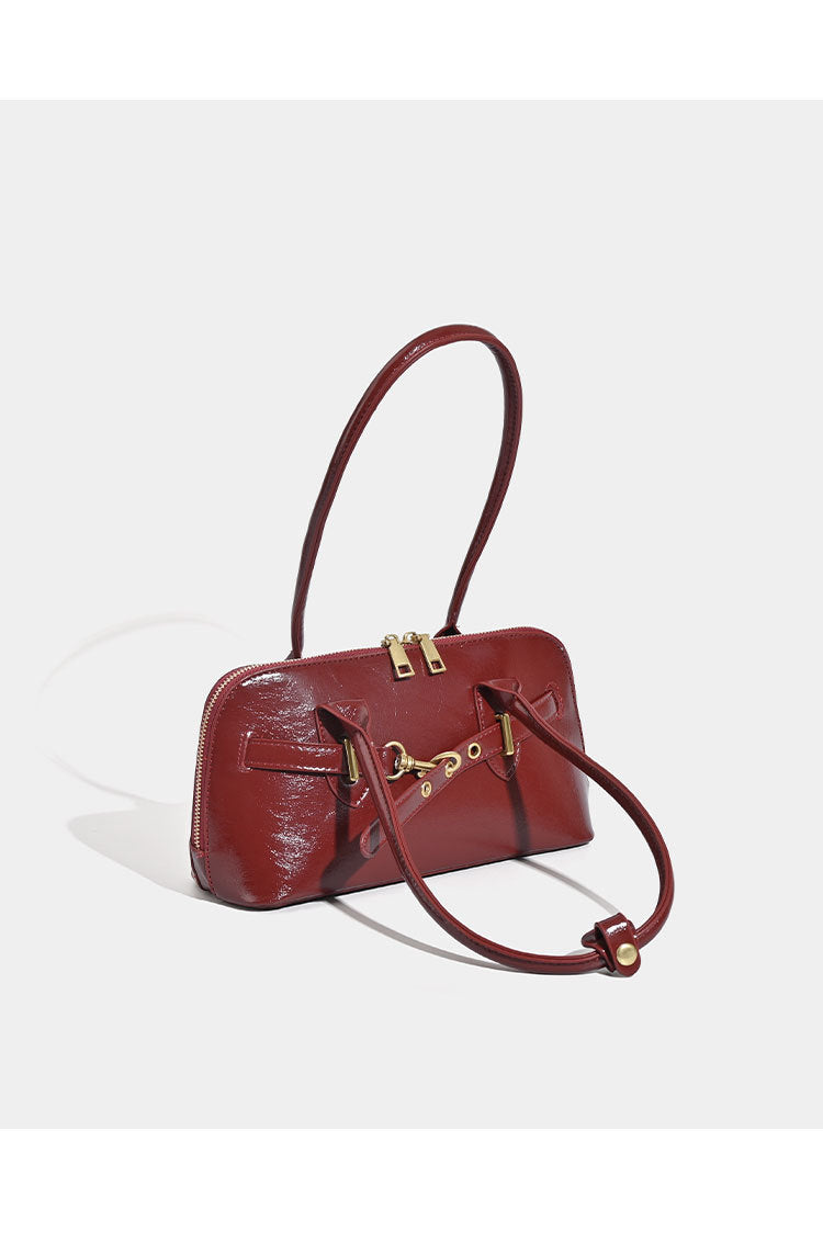 Small structured glossy leather-look shoulder bag with gold-tone buckle hardware and twin top handles, detail view 9