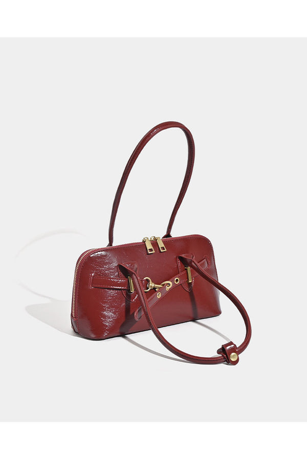 Small structured glossy leather-look shoulder bag with gold-tone buckle hardware and twin top handles, detail view 9