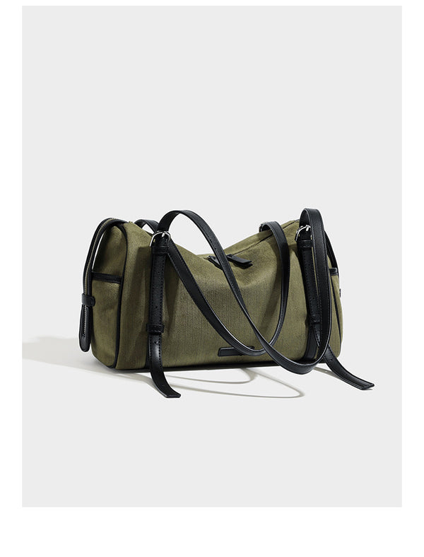 Olivgrüne Schultertasche in Zylinderform aus Canvas mit Riemen in schwarzer Lederoptik, Reißverschluss oben und silberfarbenen Beschlägen, Detailansicht
