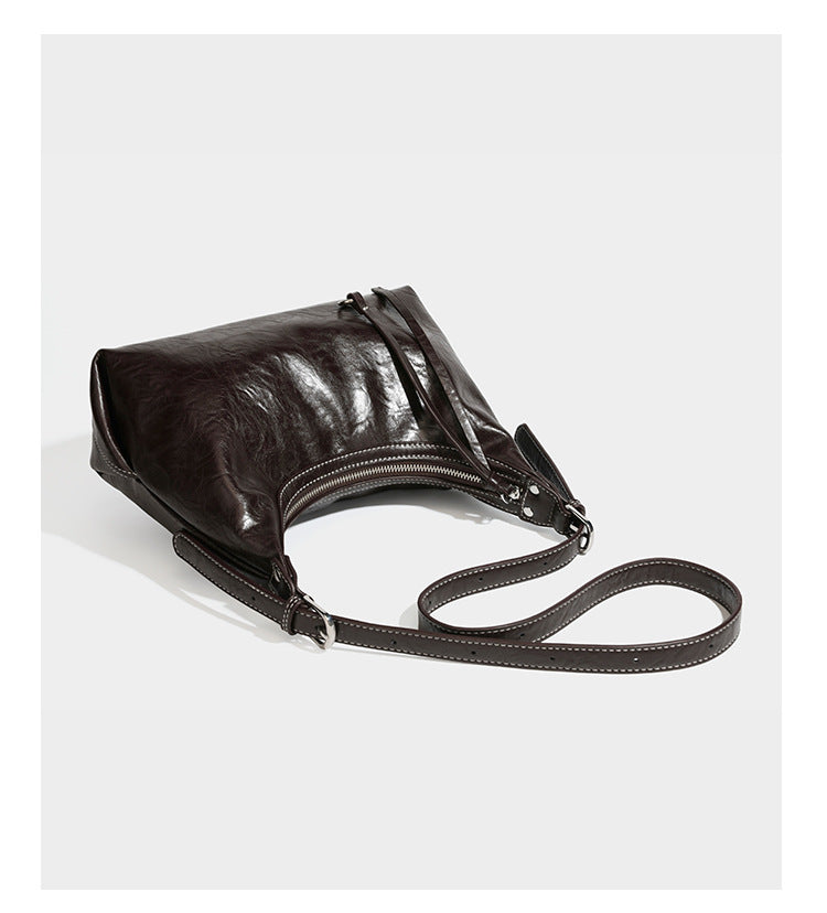 Slouchy hobo shoulder bag in glossy crinkled leather-look finish with zip-top closure and silver-tone ring hardware, detail