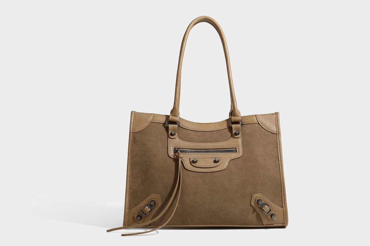 Large structured tote bag with matte suede-like body, smooth leather-look trim, front zip pocket, stud hardware, and
