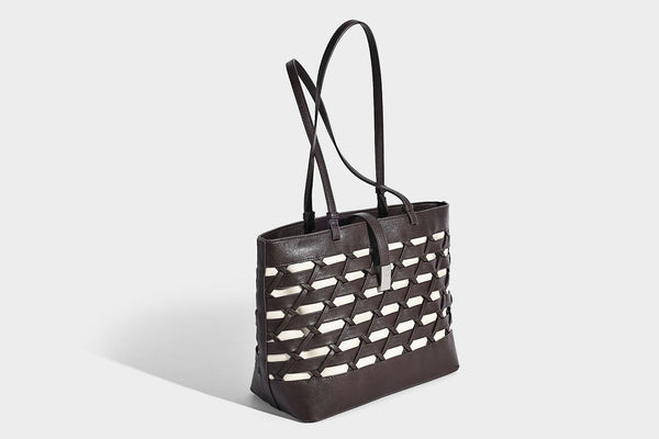 Structured woven lattice cutout tote bag with smooth leather-look trim, dual shoulder straps, and silver-tone hardware