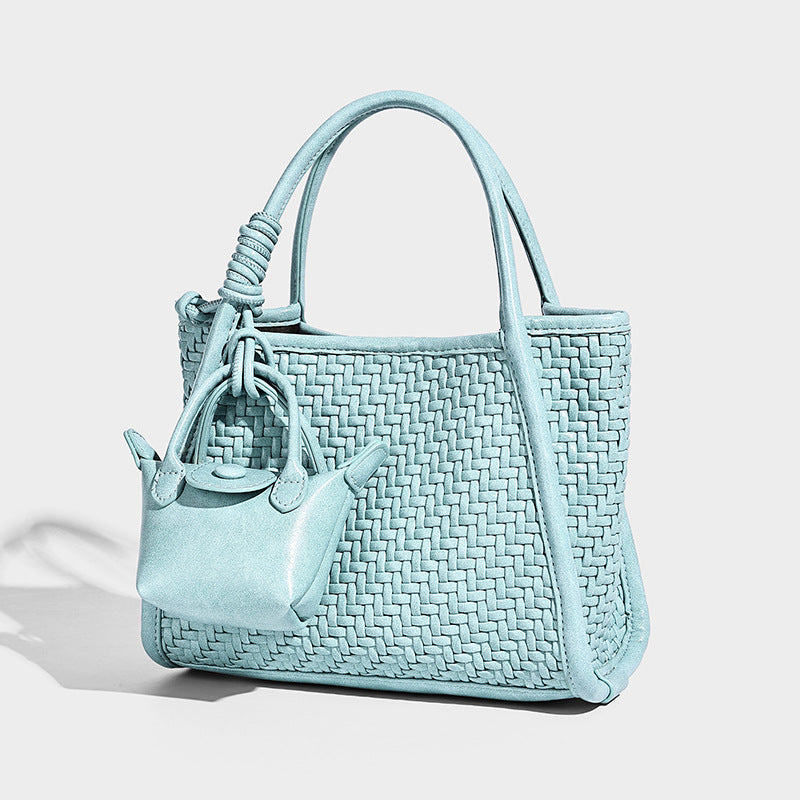 Structured woven basket-weave tote bag with mini pouch charm, rounded top handles, and detachable shoulder strap, front view