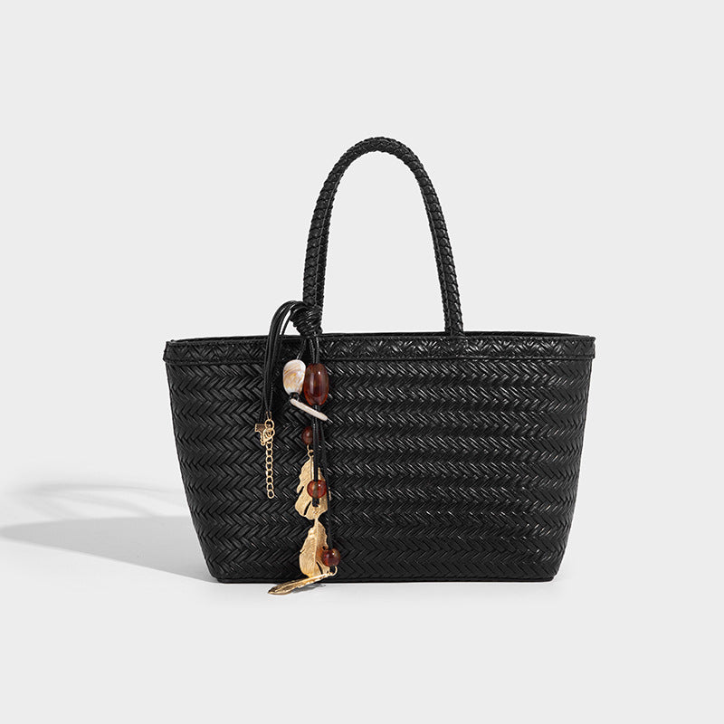 Structured chevron woven leather-look tote bag with braided top handles, gold feather charm, and adjustable shoulder strap