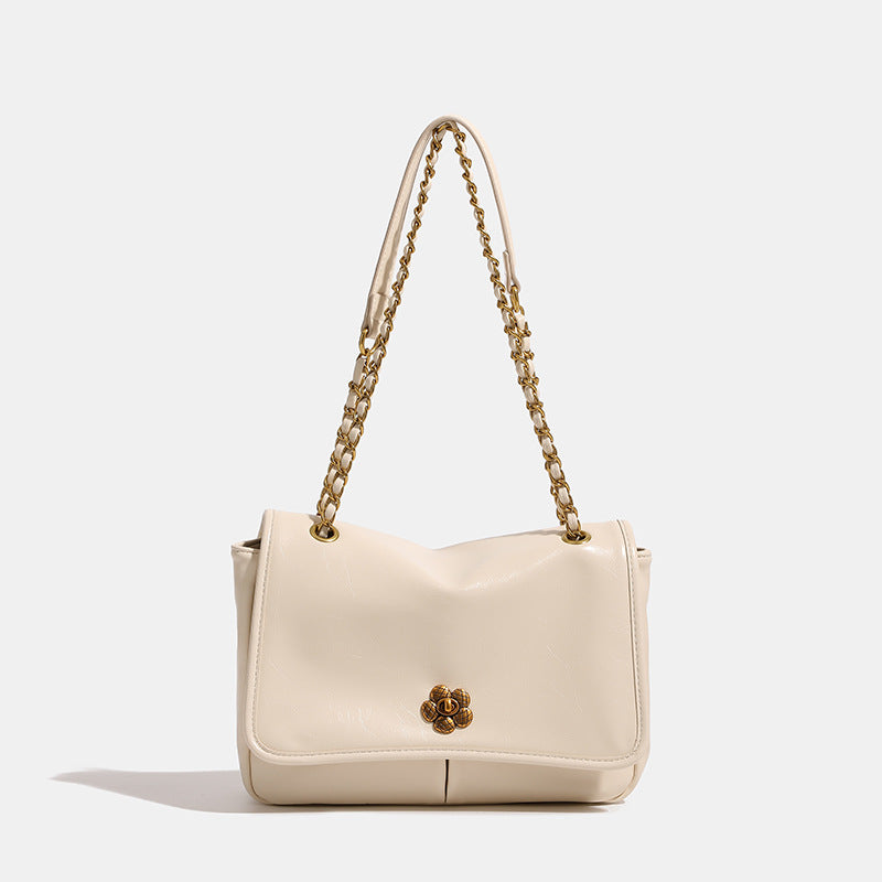 Structured flap shoulder bag with antique gold-tone chain strap and flower turn-lock clasp in crinkled leather-look finish