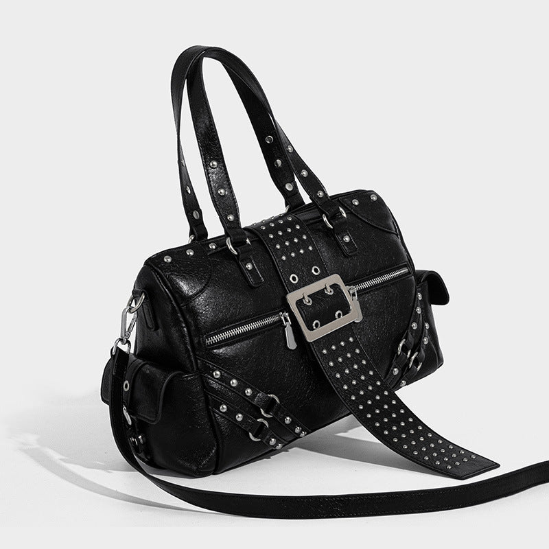Black glossy pebbled-texture satchel bag with silver studs, buckle strap detail, dual top handles, and wide studded shoulder