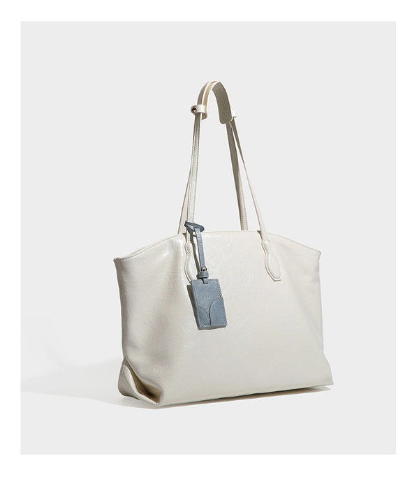 Übergroße, weich fallende Tote-Bag in dunklem Bordeauxrot mit glänzender, geknautschter Lederoptik, zwei langen Schulterriemen und Kontrast