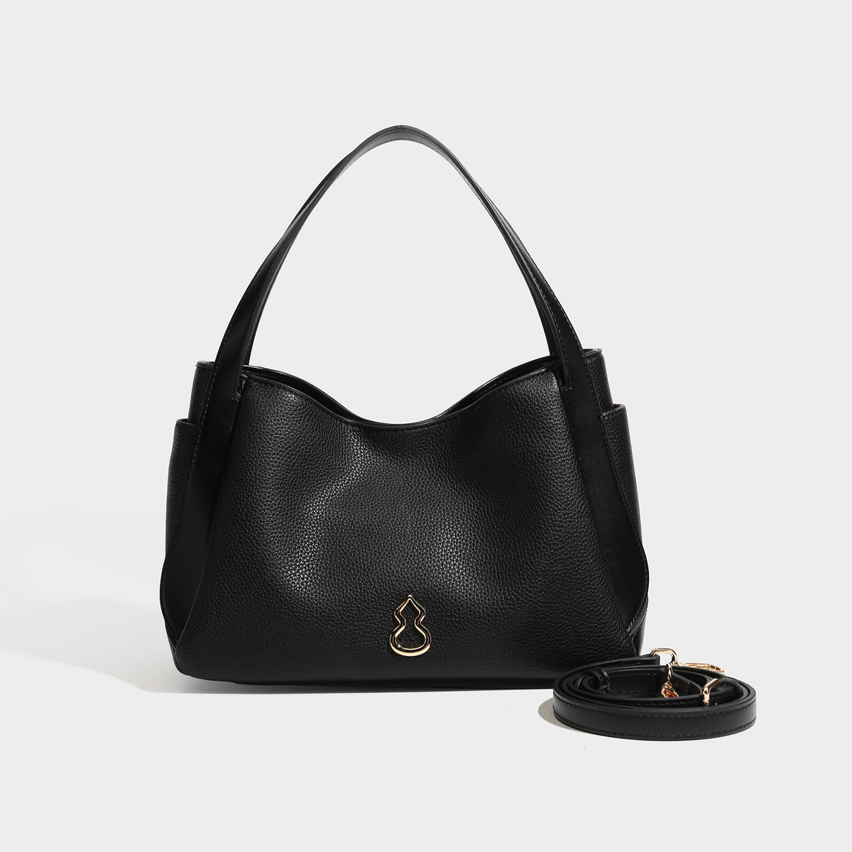 Schwarze Tote-Bag in genarbter Lederoptik mit kürbisförmigen Beschlägen in Goldoptik, zwei Tragegriffen und abnehmbarem Crossbody-Schulterriemen, Detailansicht