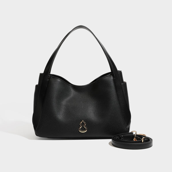 Schwarze Tote-Bag in genarbter Lederoptik mit kürbisförmigen Beschlägen in Goldoptik, zwei Tragegriffen und abnehmbarem Crossbody-Schulterriemen, Detailansicht