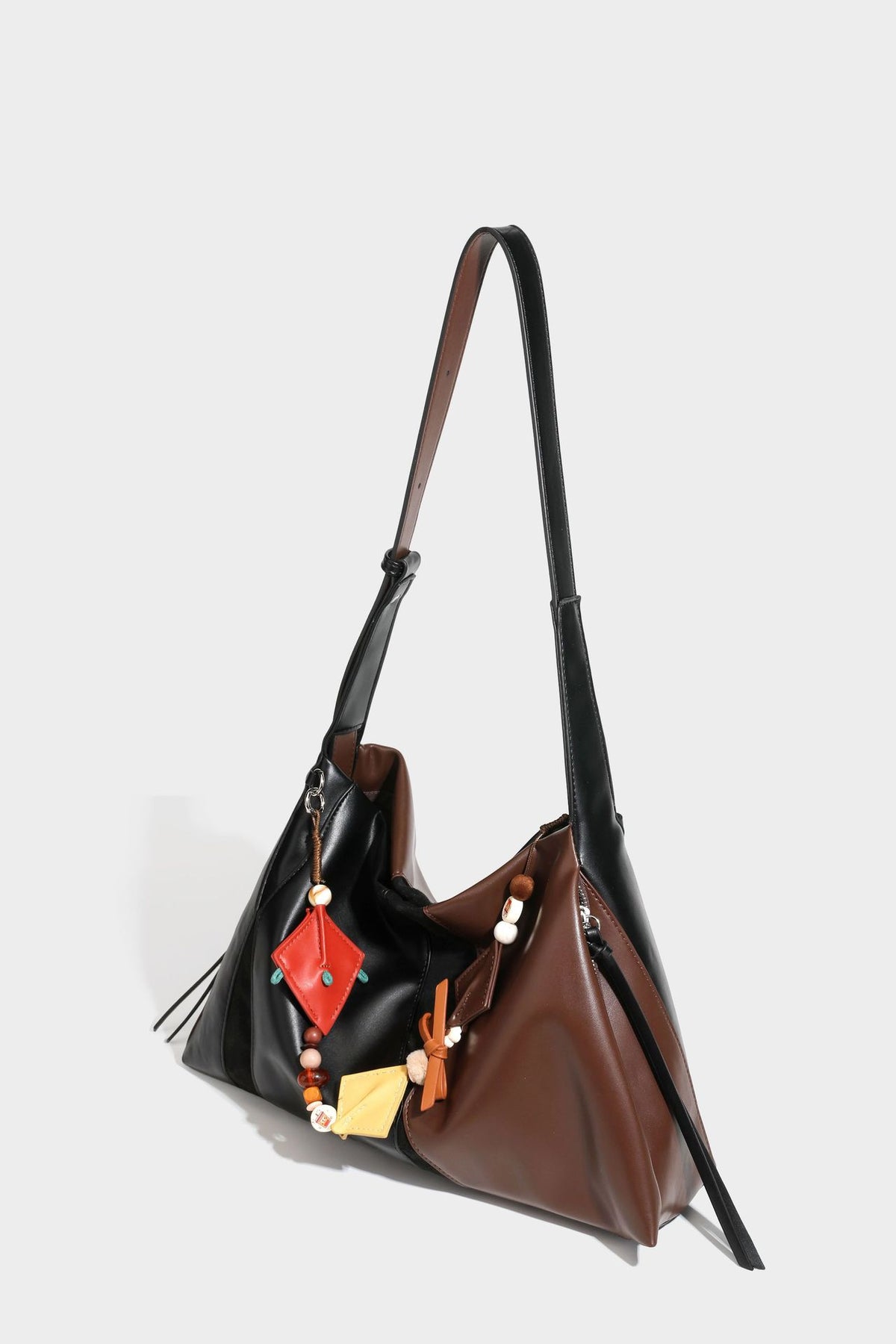 Two-tone black and brown leather-look slouchy shoulder bag with beaded tassel charm and silver-tone hardware, detail view 28