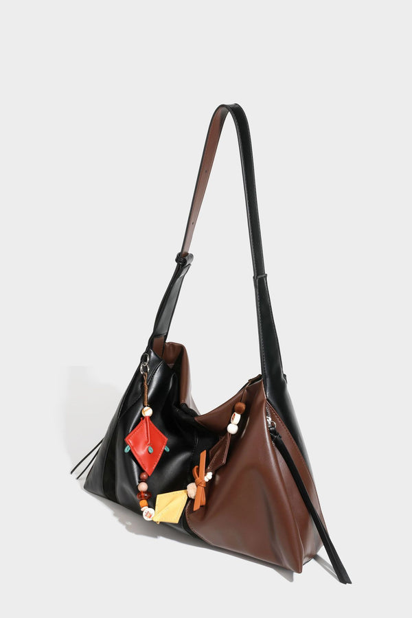 Two-tone black and brown leather-look slouchy shoulder bag with beaded tassel charm and silver-tone hardware, detail view 28