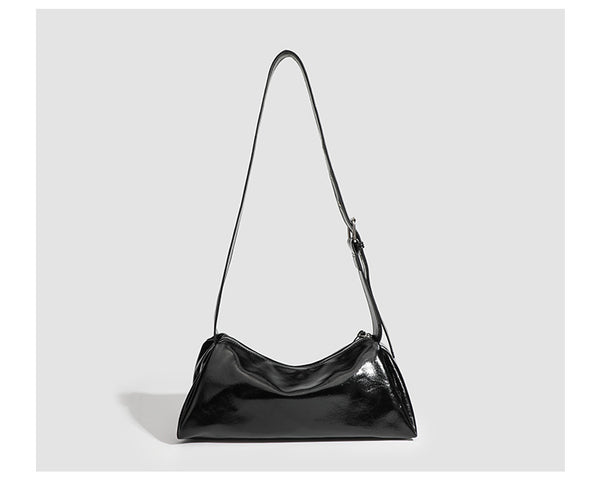 Black glossy leather-look slouchy shoulder bag with gathered top, zip tassel closure, and long adjustable silver-buckle