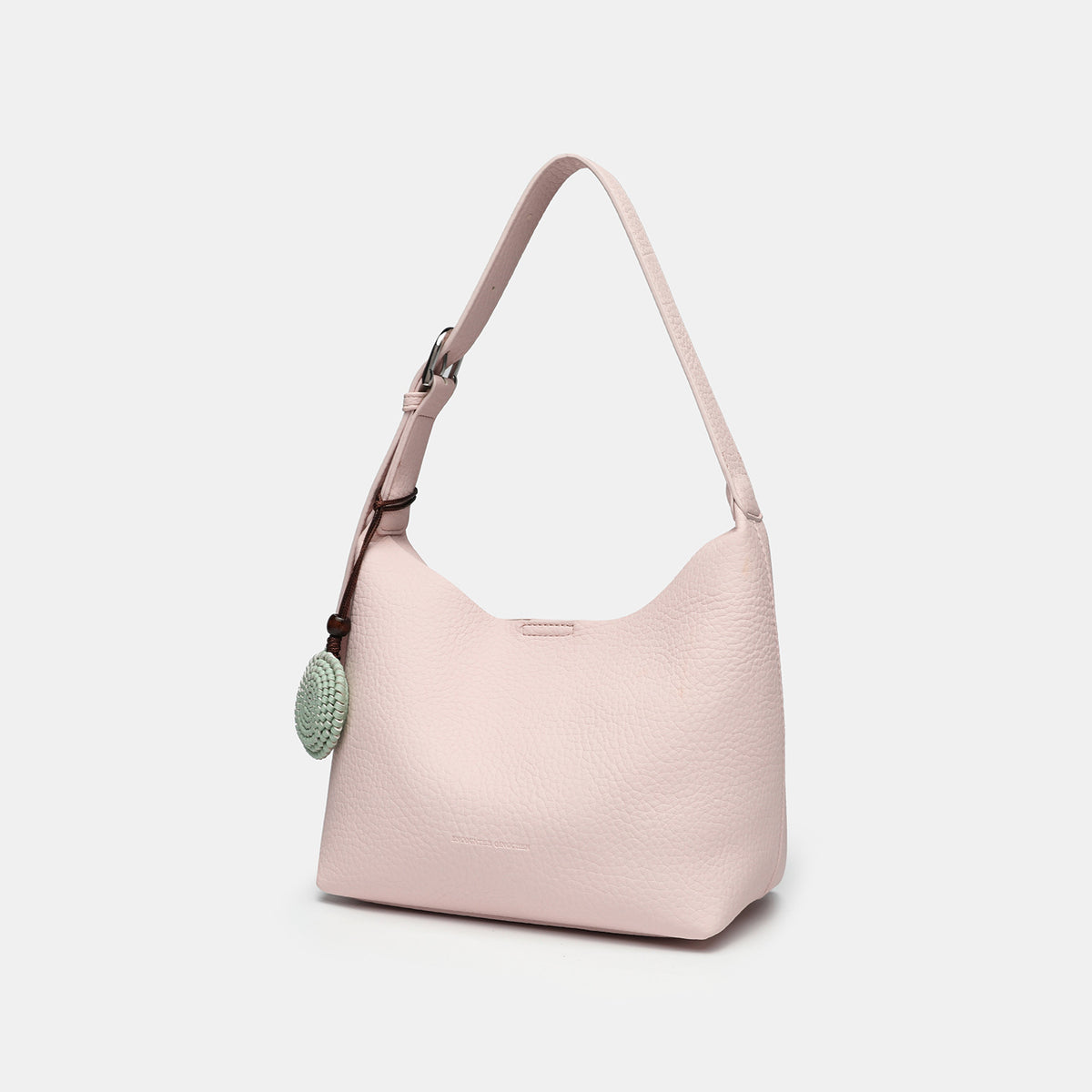 Slouchy hobo shoulder bag in pale yellow pebbled texture with woven charm, adjustable strap, matching zip pouch, and, detail