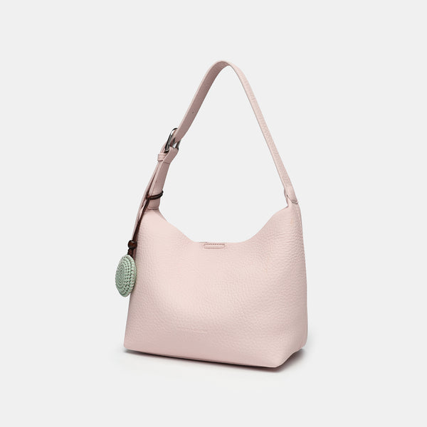 Slouchy hobo shoulder bag in pale yellow pebbled texture with woven charm, adjustable strap, matching zip pouch, and, detail