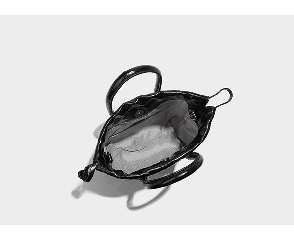 Glossy crinkled ruched drawstring bucket bag with rounded double top handles and detachable chain crossbody strap, detail